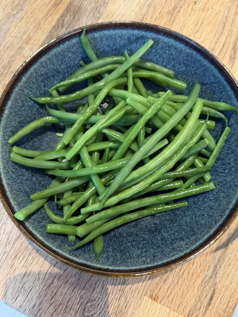 Boiled green beans in a blue bowl