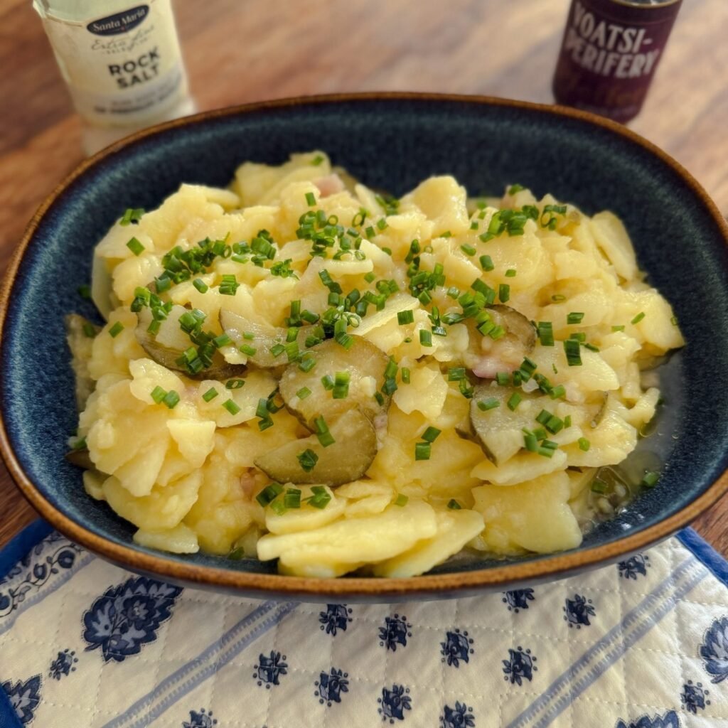 Bowl of Viennese potato salad with sliced gherkins and chives