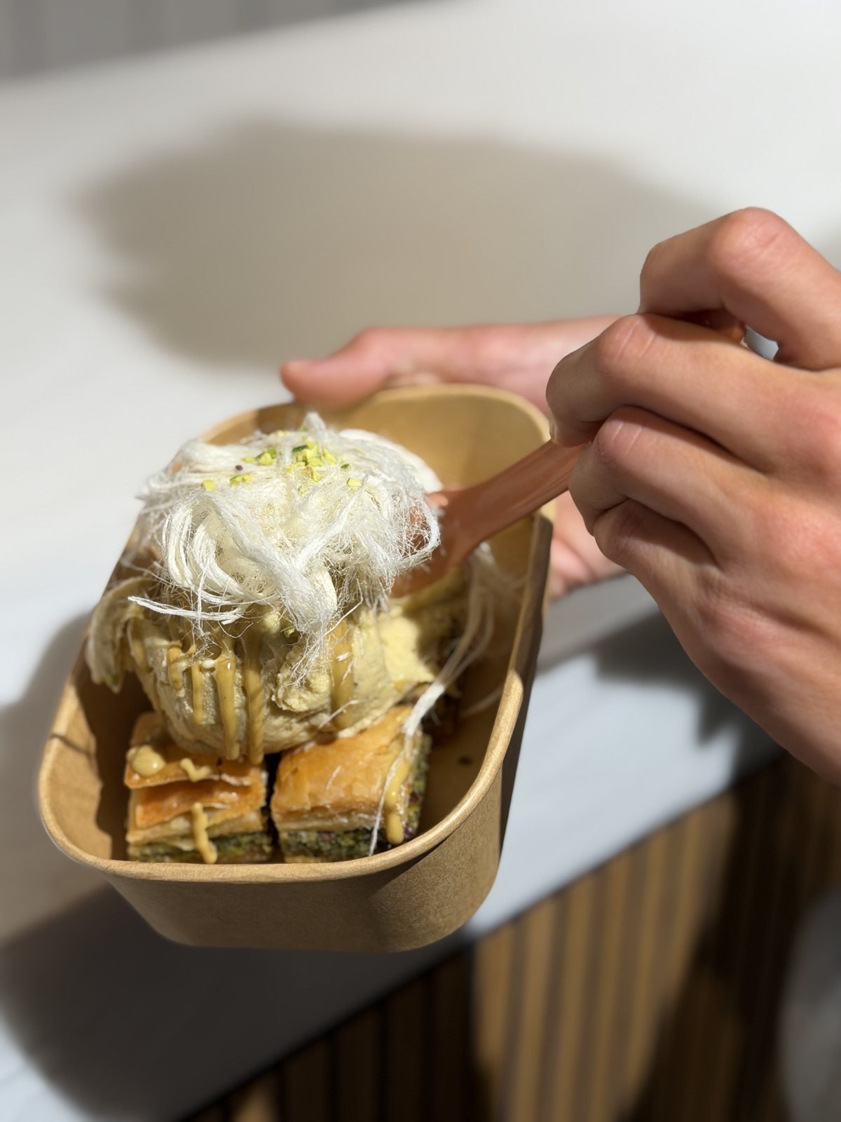 A scoop of ice cream on squares of pistachio baklava at Miska